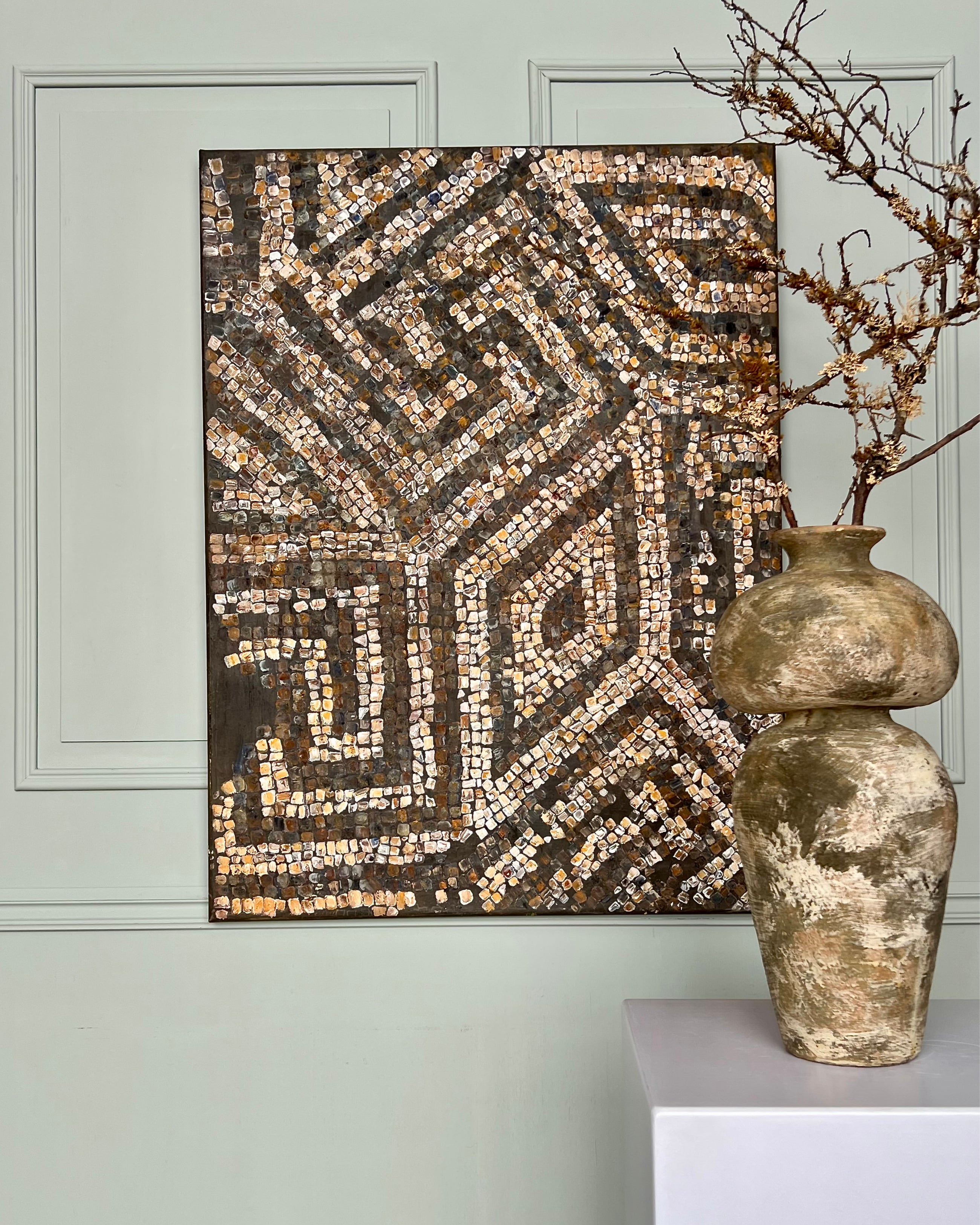 Contemporary mosaic painting styled with antique ceramics and neutral interior tones.