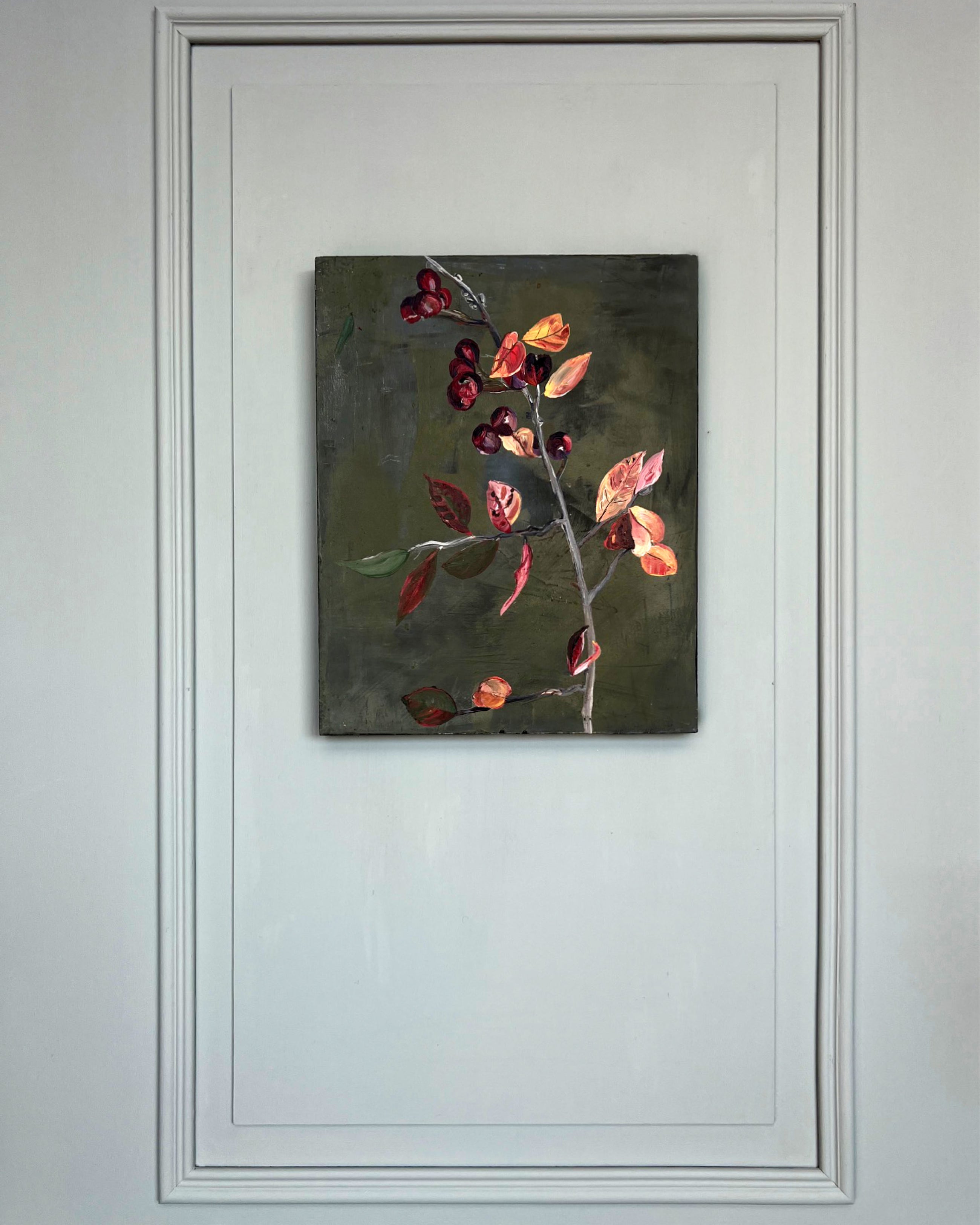 Small-format still life painting with branch, red berries and autumn leaves, mixed media on canvas in muted green and earth tones.