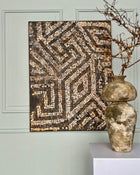 Contemporary mosaic painting styled with antique ceramics and neutral interior tones.