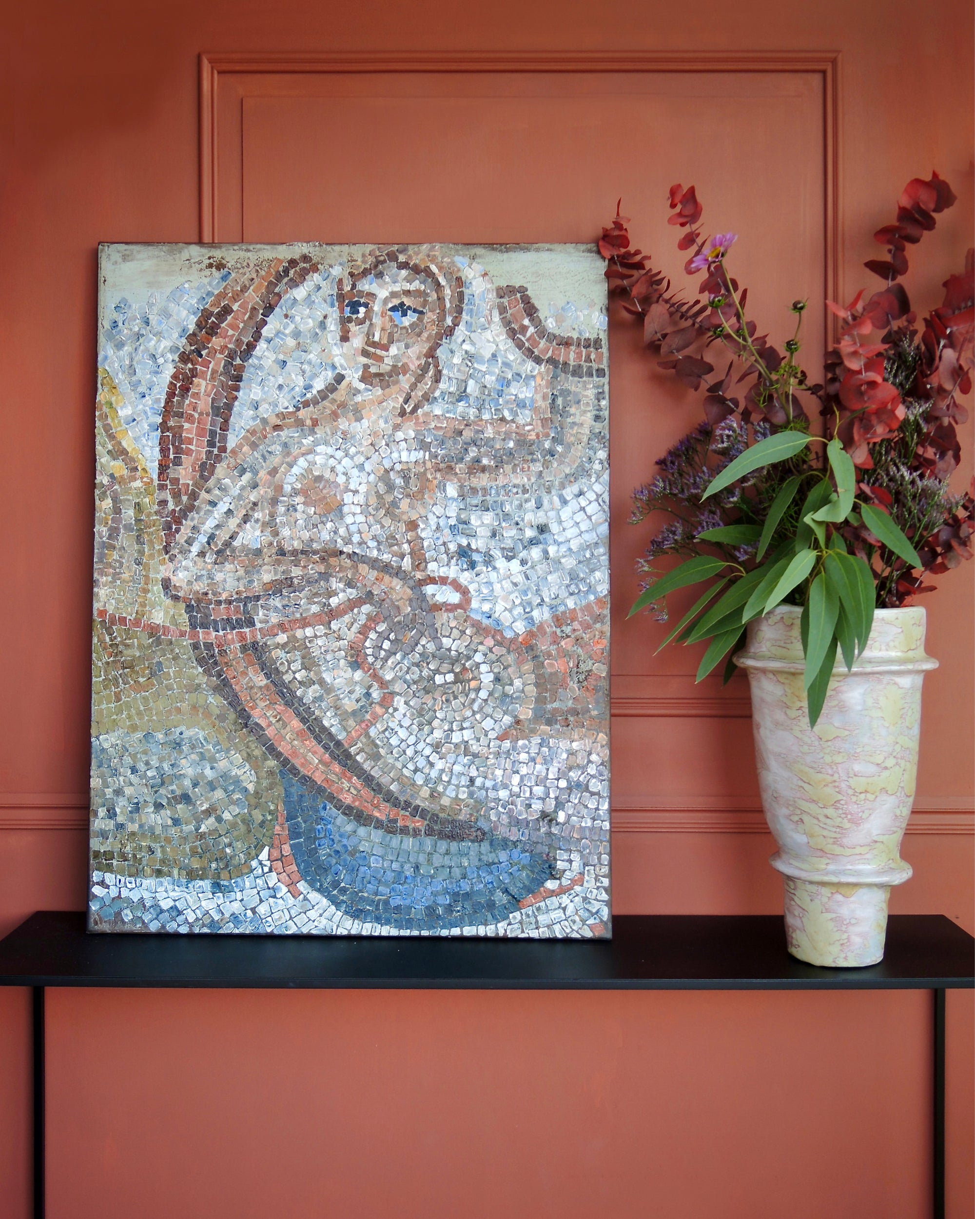 Contemporary mosaic artwork displayed in an elegant interior with classical objects and candlelight.