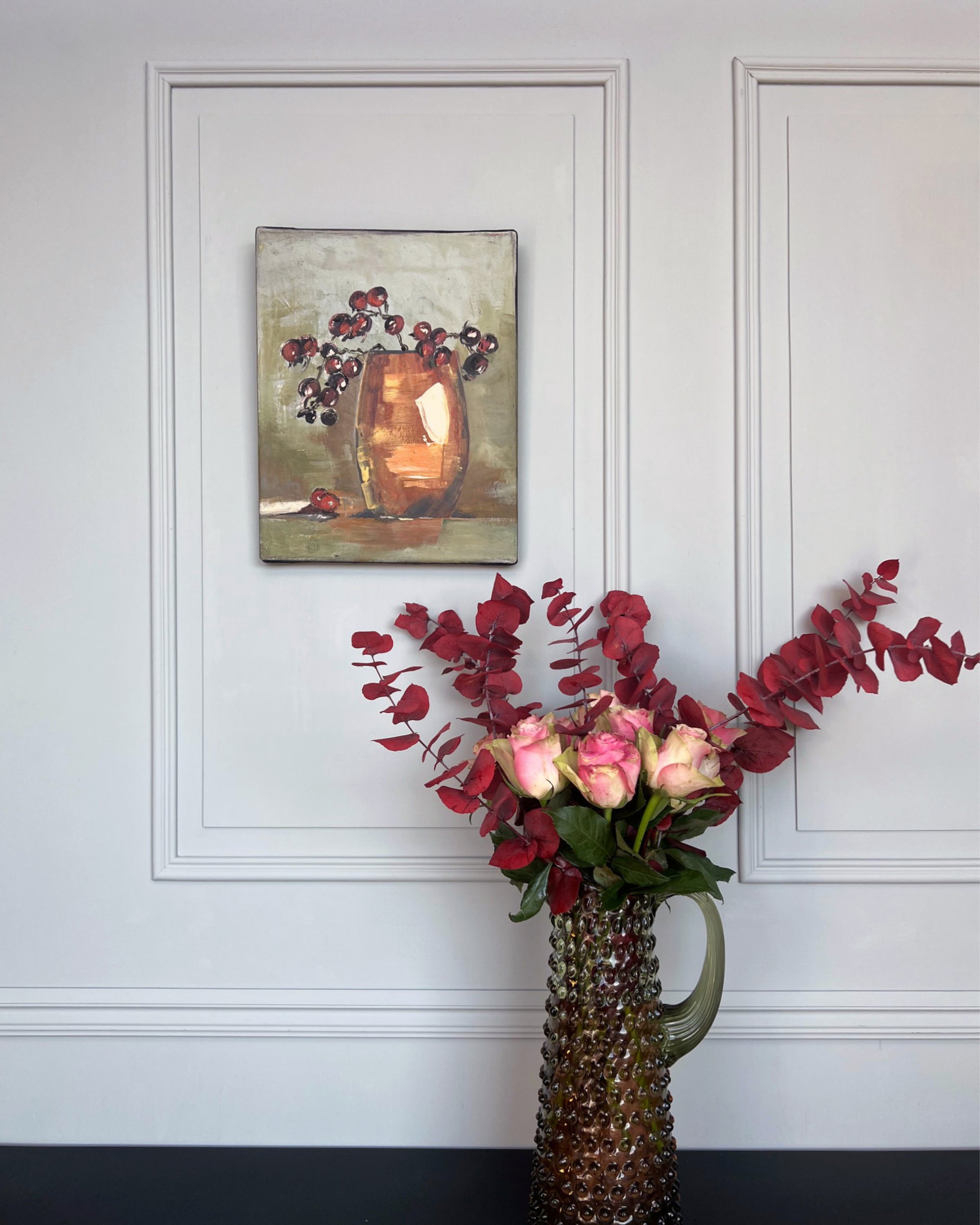 Small-format still life artwork displayed in a calm, elegant interior with flowers and neutral tones.